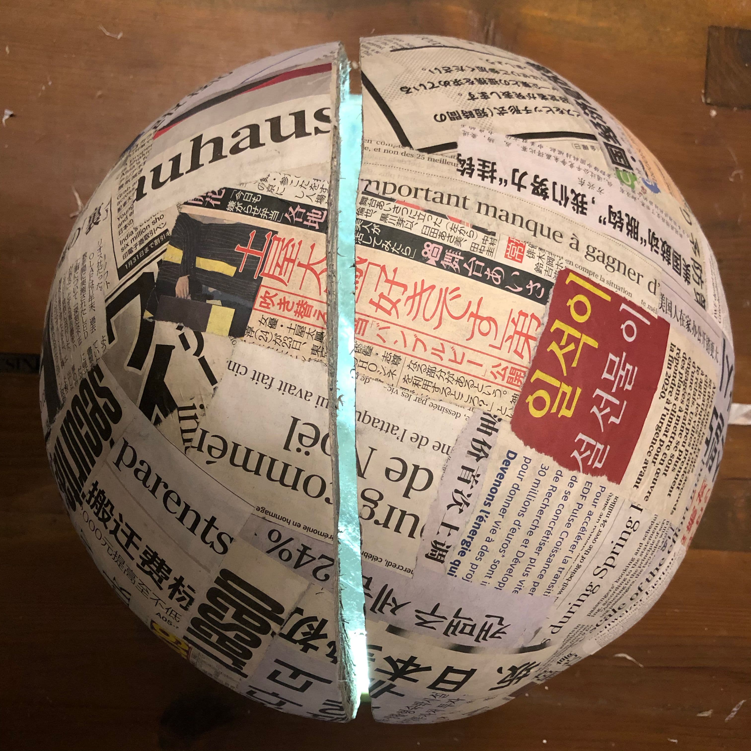 crystal ball covered in layers of newspapers, glowing from within